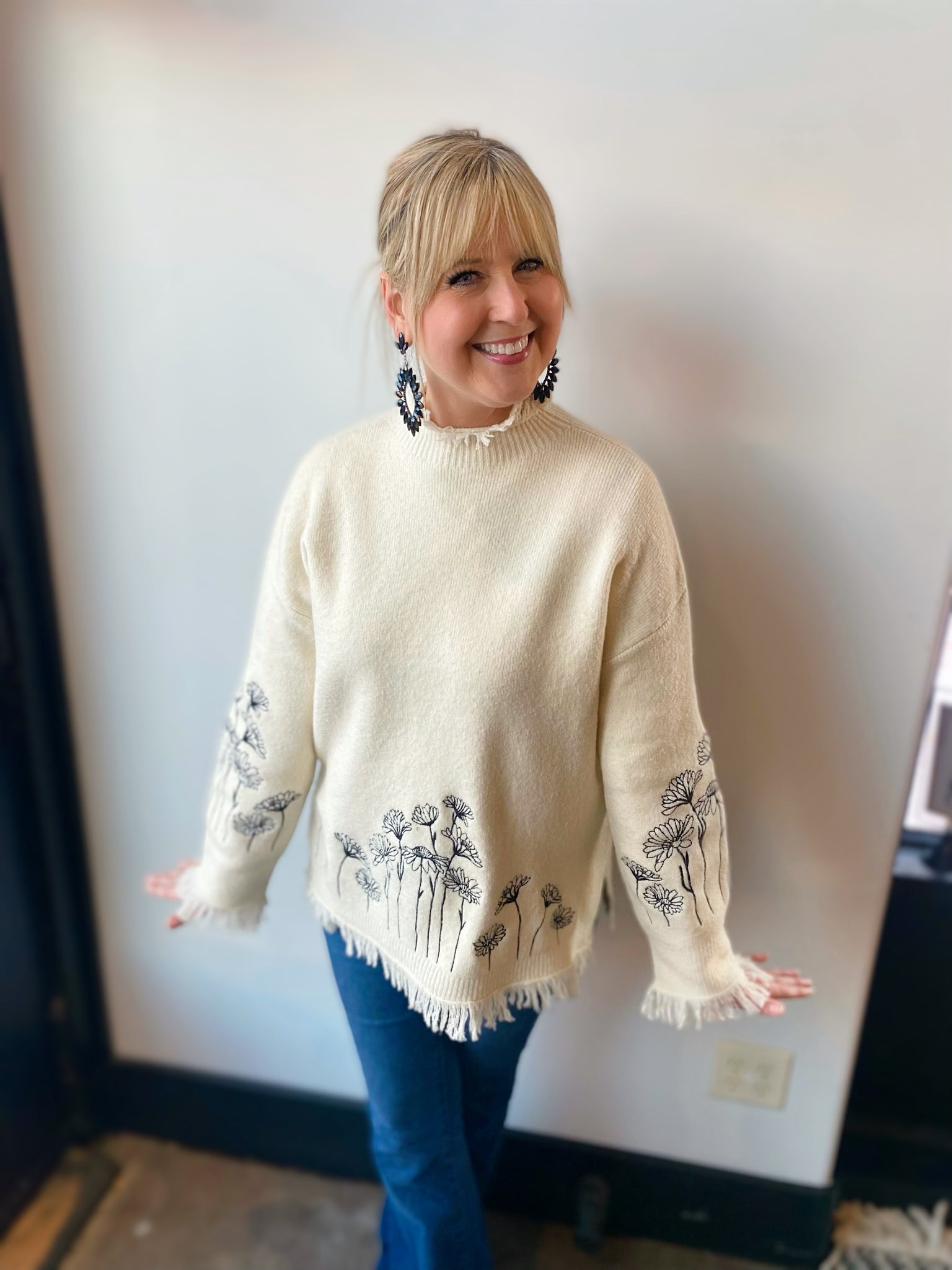 cream sweater with black embroidered flowers